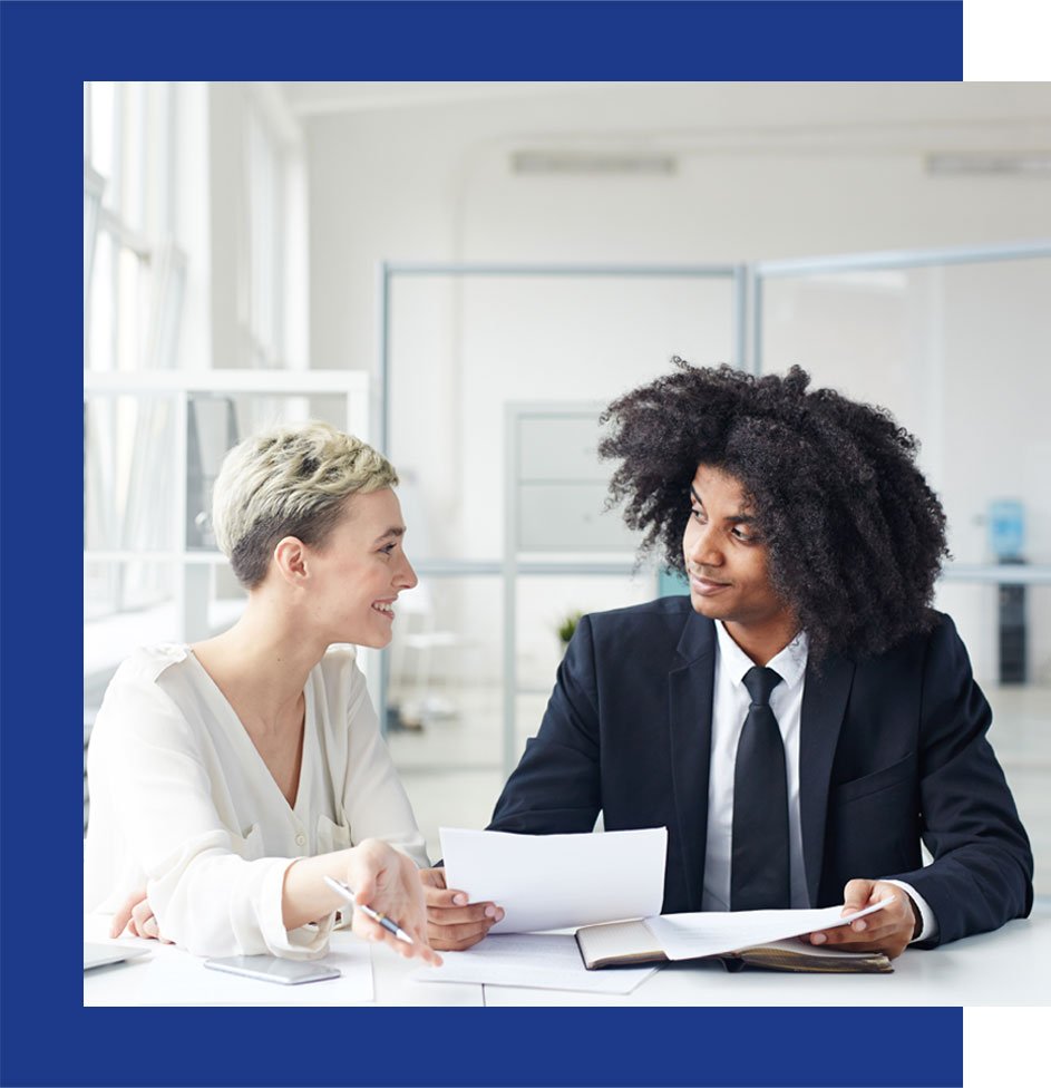 Account and customer sitting at a table looking at documents and discussing them