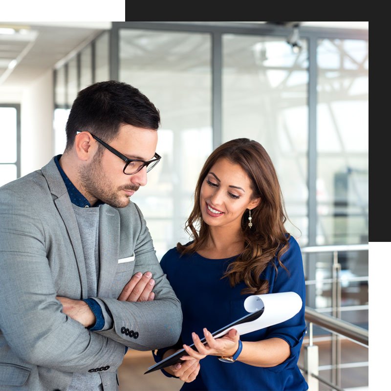 Female accountant holding and showing a document to a male customer while standing