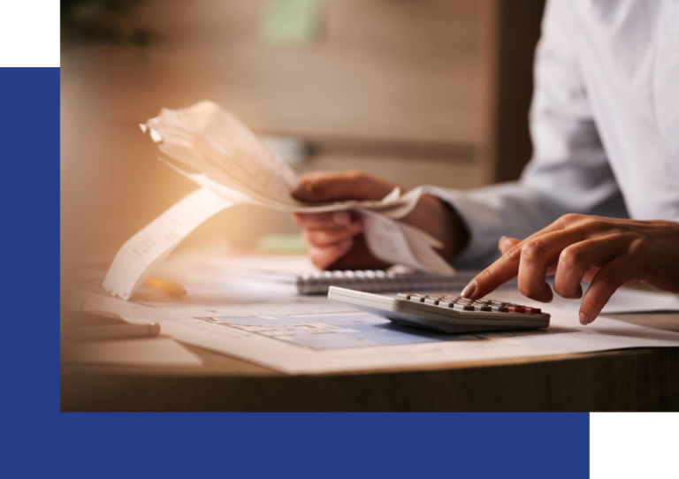 Closeup of an accountant using calculator while going through bills and taxes at an office sitting at a desk